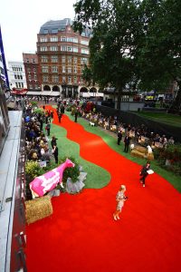 An event, possibly a movie premiere, with red carper and artificial grass