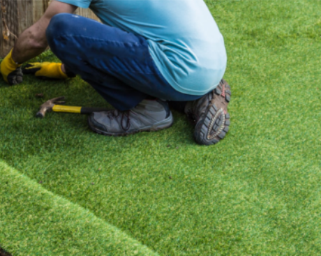 A man installs artificial grass